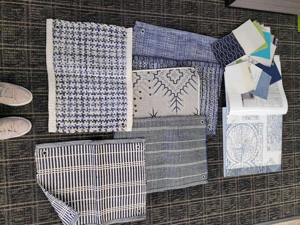 Blue and white fabric samples laid out on carpet