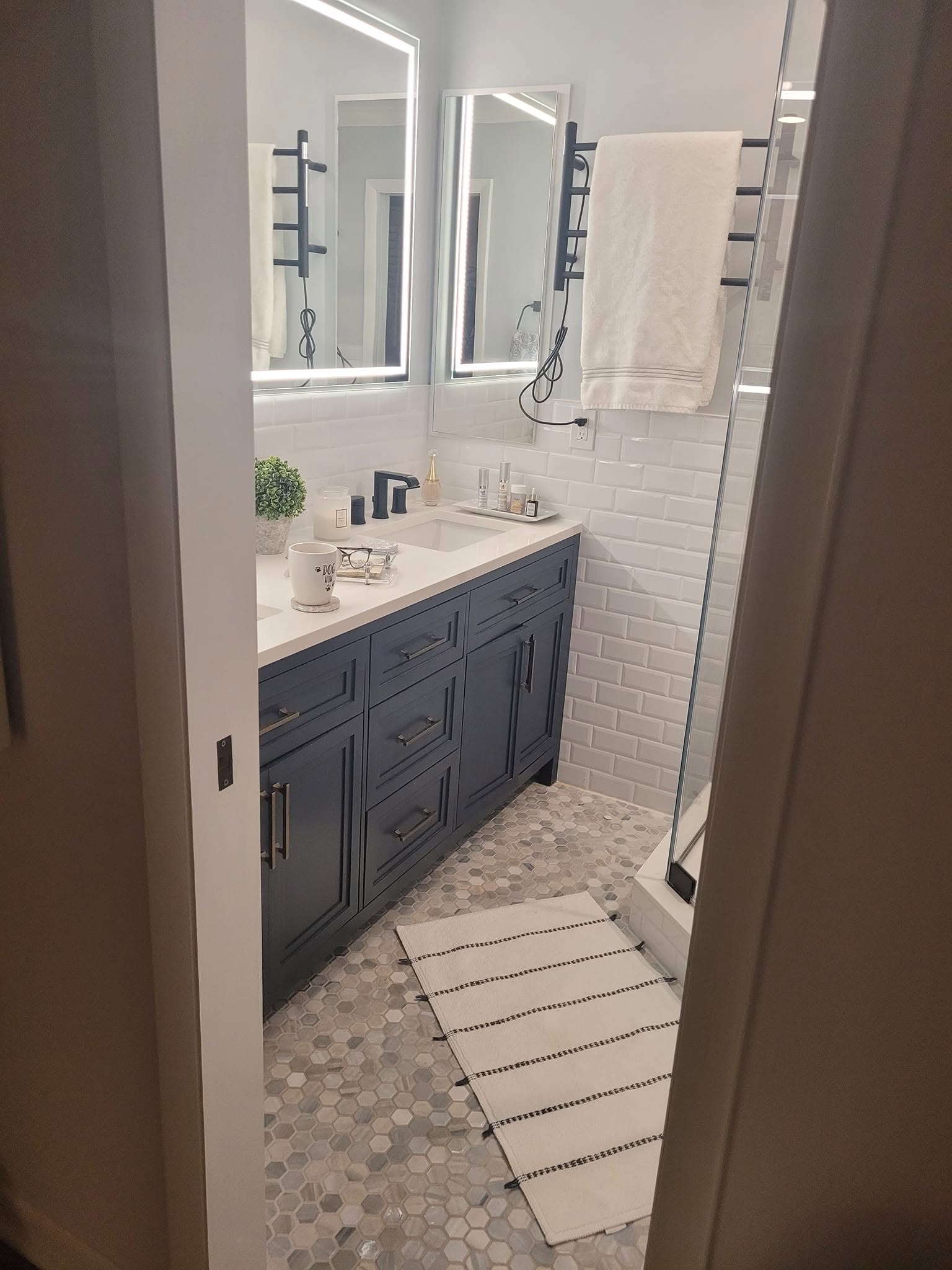 Bathroom vanity with navy cabinets, a white countertop, and hexagon floor tile